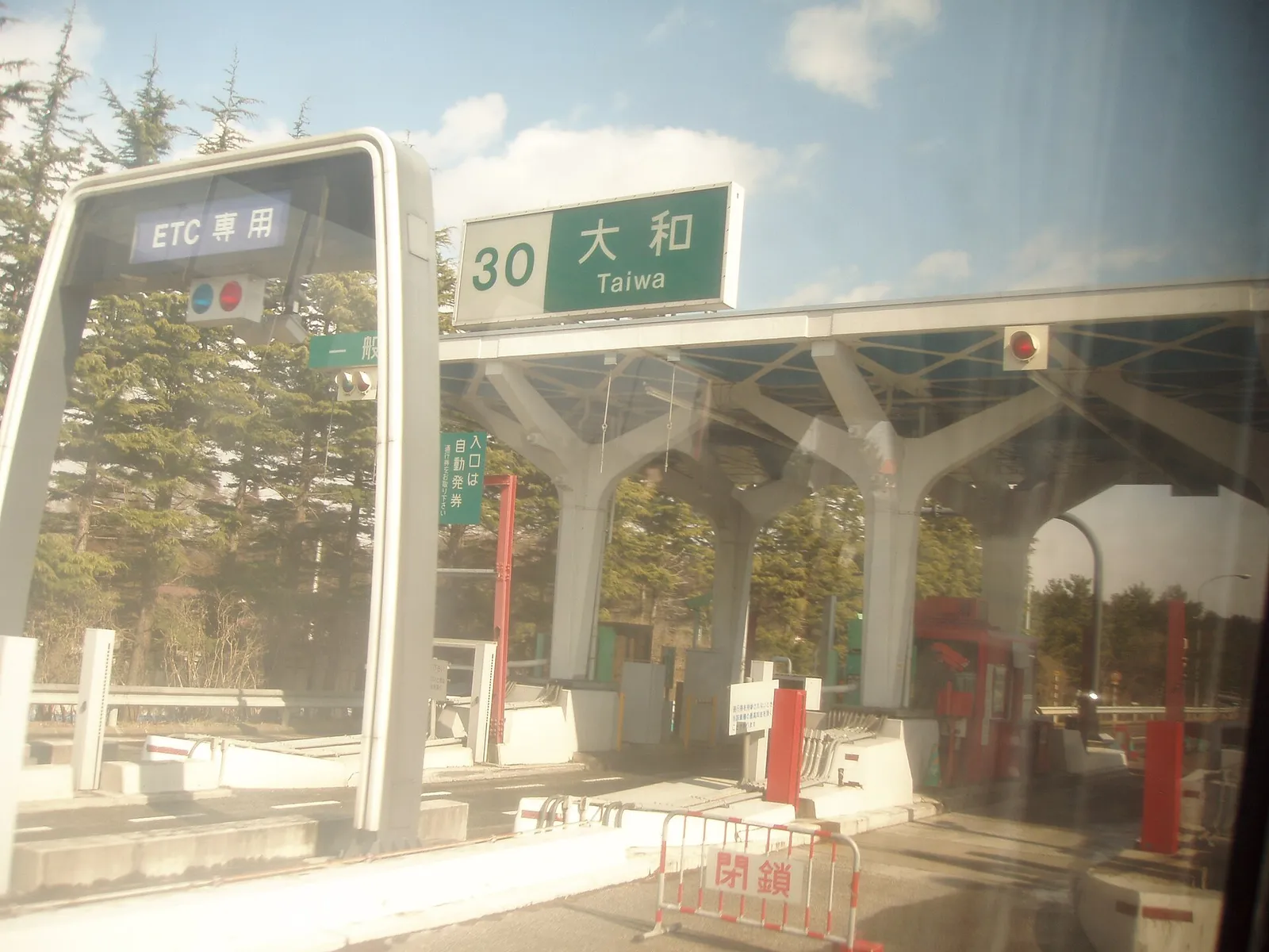 An electronic toll gate on a Japanese expressway, with the lane barrier and overhead signage