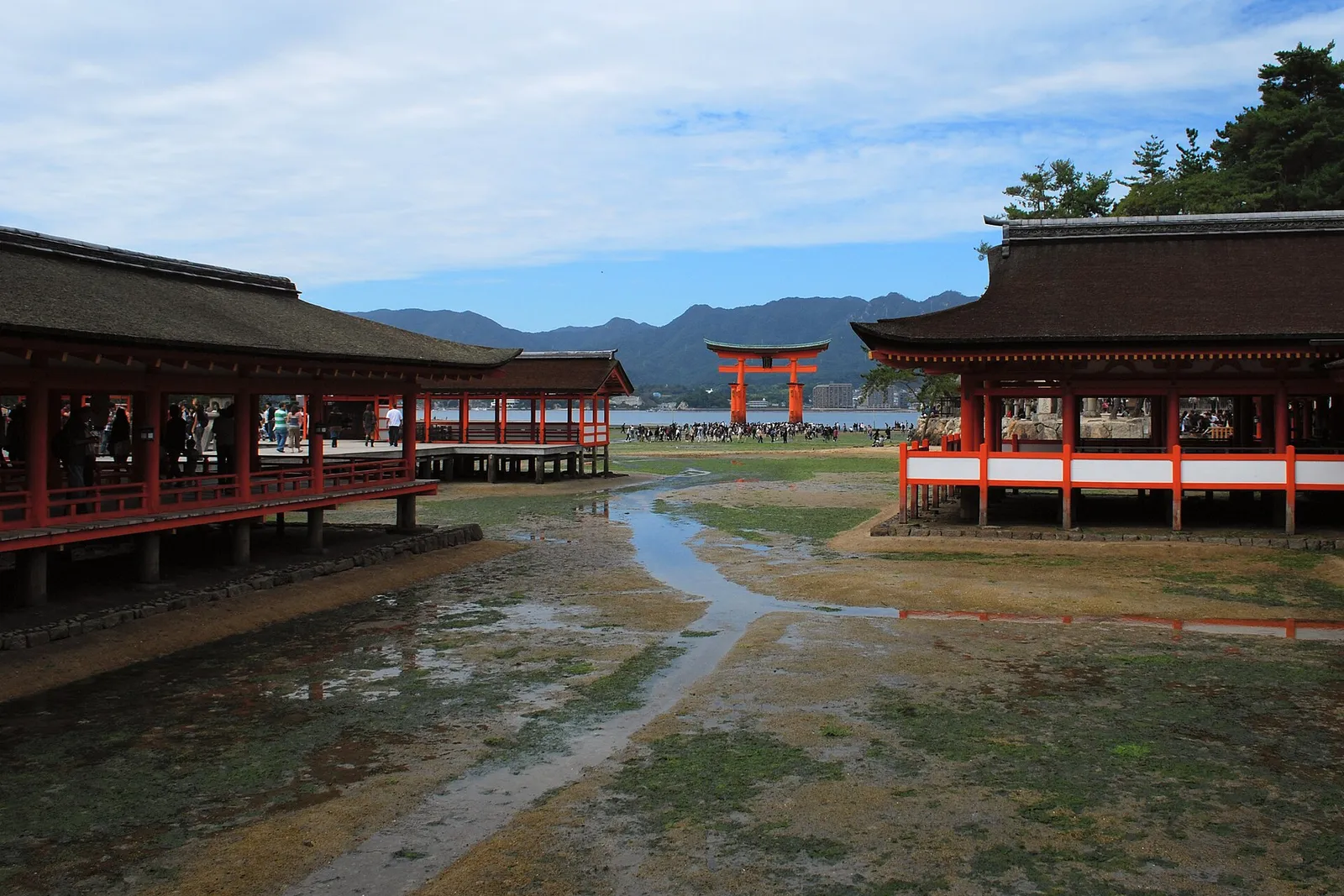 The stilted corridors of Itsukushima Shrine on Miyajima with the torii gate beyond it on the tidal flat at low water