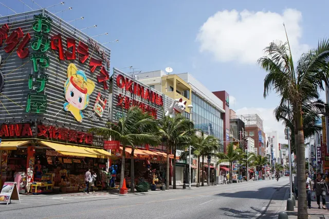 Busy street lined with colourful shop signs and palm trees