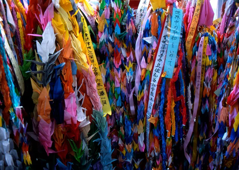Chains of thousands of colourful paper cranes with banners from schools