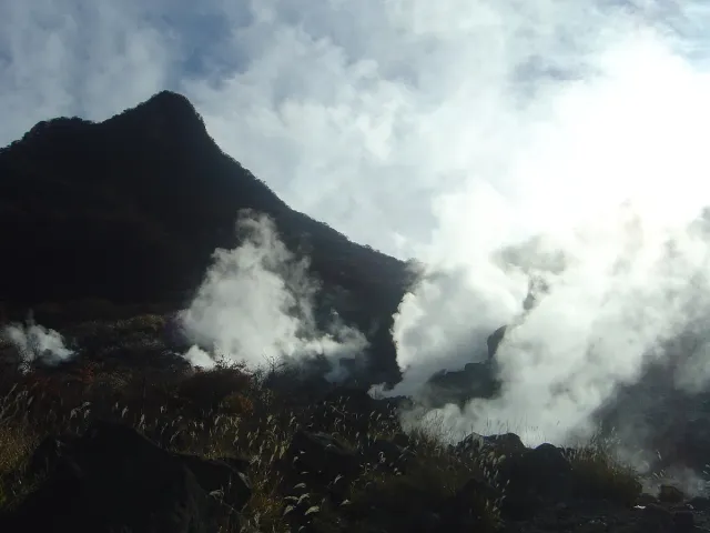 White steam rising from a bare volcanic ridge