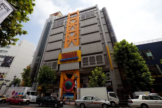 A tall building with bold yellow signage seen from street level