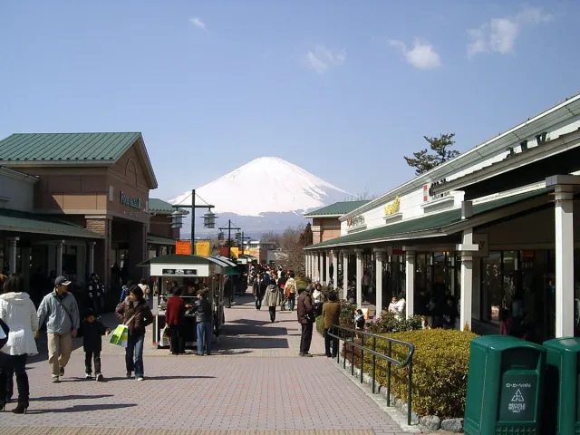 An outlet walkway with shoppers and a snow-capped mountain behind