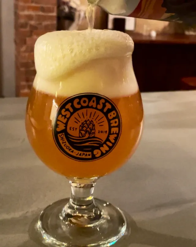 Beer poured into a glass goblet with a printed emblem and a high white head