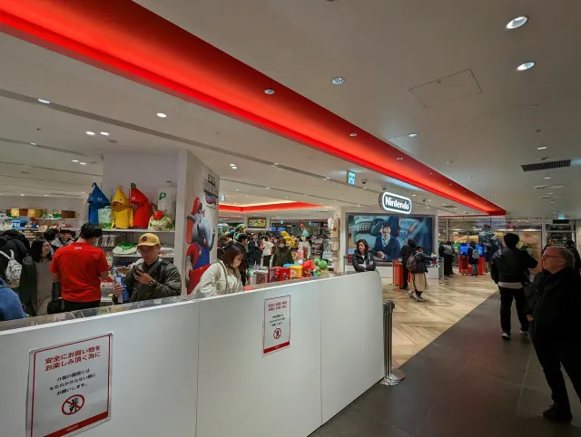 A store interior with a glowing red ceiling and shoppers inside