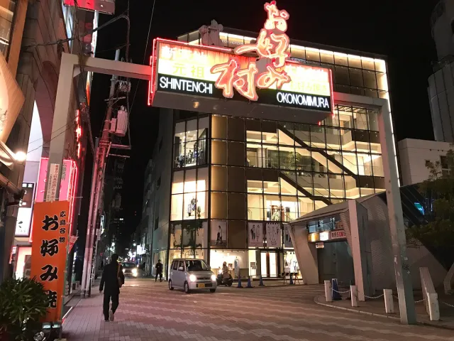 A building front at night with red neon signs