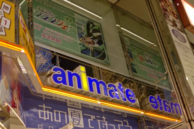 A shop front with signage lit in blue and orange