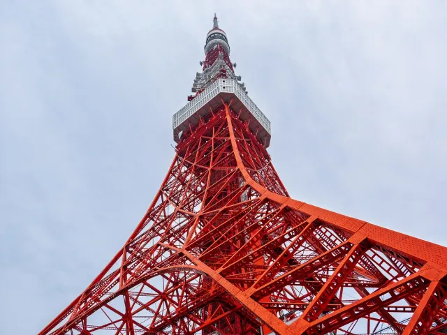 A red and white steel lattice tower seen from below