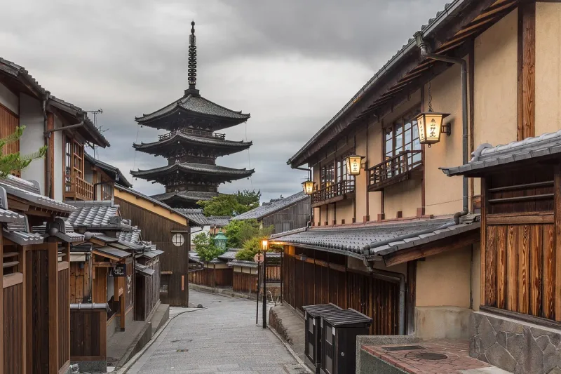 A five storey pagoda at the end of a Kyoto residential lane, with wooden facades and street lanterns