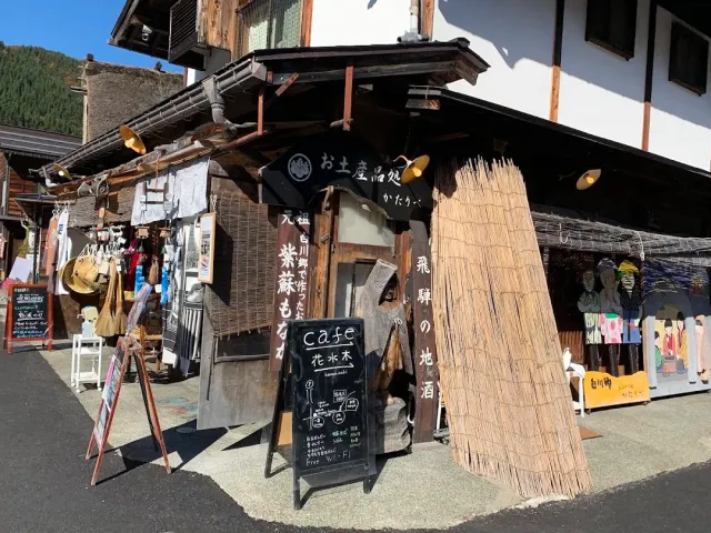 A rural shop front with cloth curtains, a chalkboard and a large straw bundle