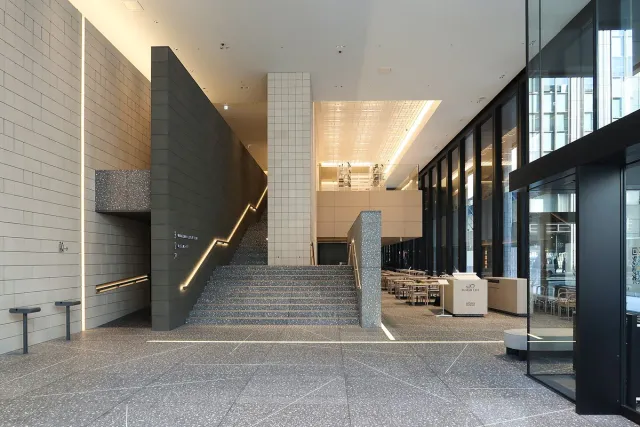 A bright museum lobby with wide stairs and a glass front