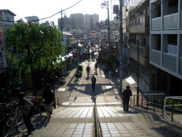 A narrow shopping street descending by steps, with a few passers-by