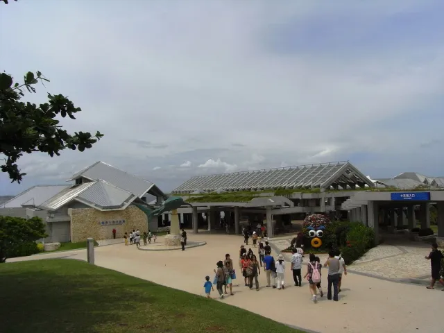A low building with a curved roof and visitors at the entrance