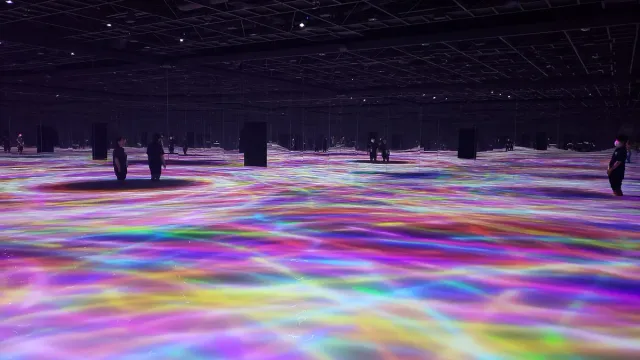 A floor of rippling coloured light in a dark room