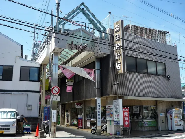 A covered shopping street with protruding signs on both sides