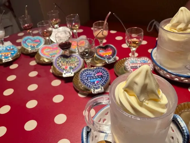 Liqueur glasses and cups of soft ice cream on a red cloth with white dots