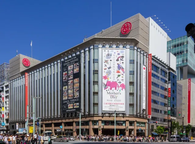 A large department store building at a city junction with billboards