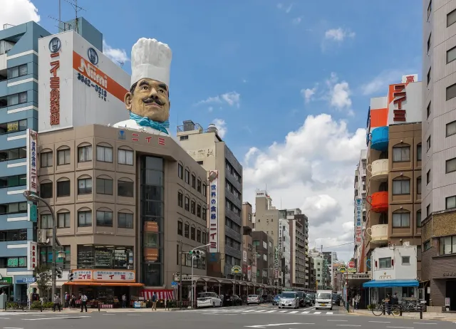 A street corner with a giant chef's head on a building roof