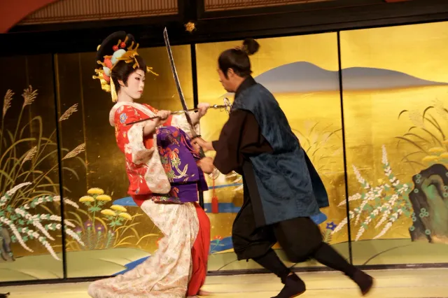 A performance in period costume on a gilded stage