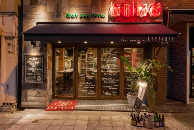 A night facade with a red neon sign, a dark awning and menus on the glass