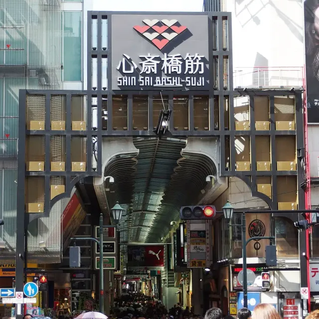 The covered entrance to a shopping street with a large sign above
