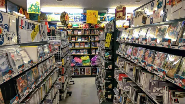 A narrow aisle in a game shop with shelves packed floor to ceiling