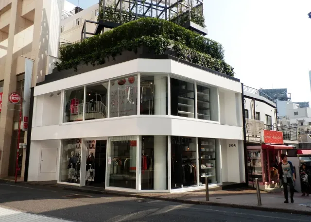 A white, modern store building on a street corner