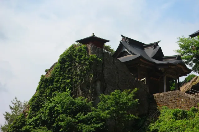 Wooden temple buildings among trees on a steep slope