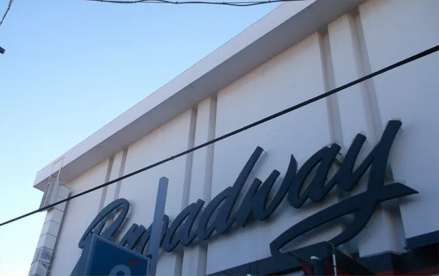A large cursive Broadway sign on the front of a building