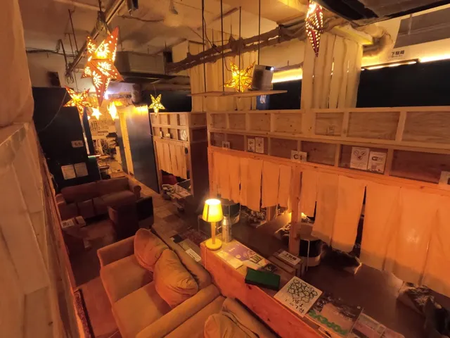 A seating area with soft sofas, hanging star lamps and light fabric curtains