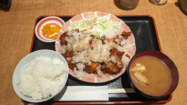 A tray with fried chicken and grated radish, a bowl of rice and miso soup