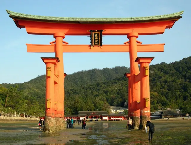 A giant orange torii gate standing in shallow water