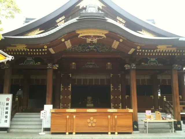 A wooden shrine hall with white curtains and gold crests