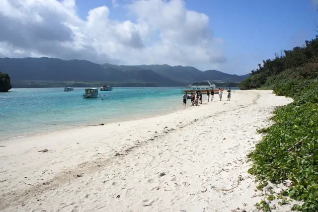A bay with white sand, turquoise water and moored boats