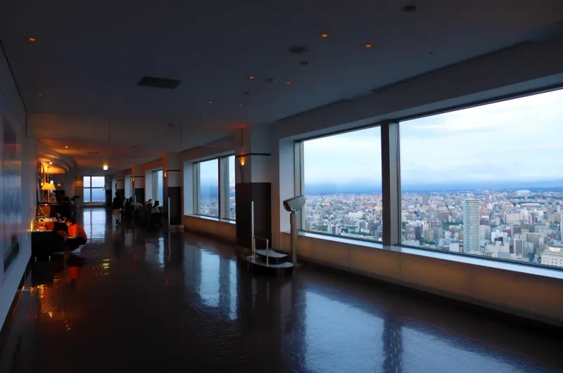 A high floor observation corridor with long windows and a view over the city
