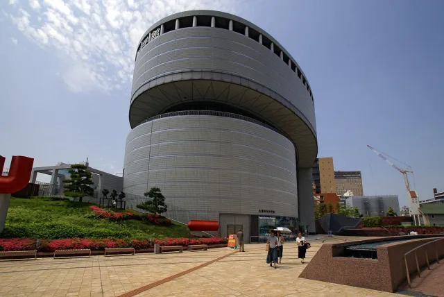 A grey cylindrical museum building with a curved front