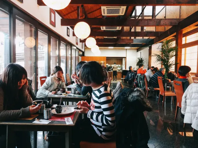 Customers seated along wooden tables in a tea house
