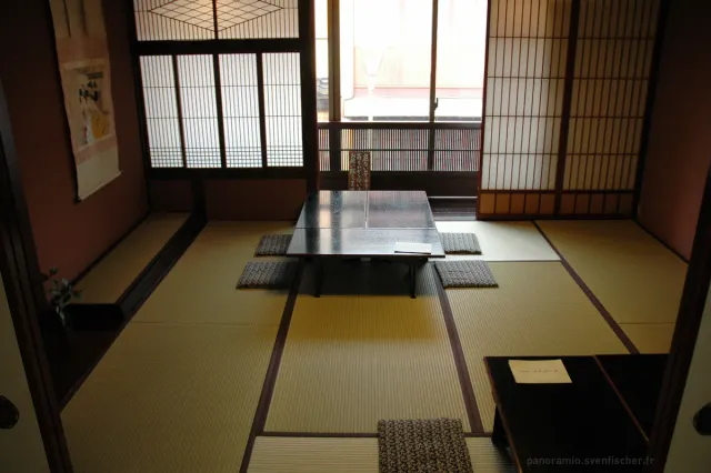 A tatami room with a low table and wooden lattice windows