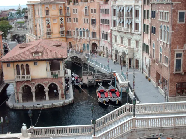 A canal with gondolas between Venetian-style buildings