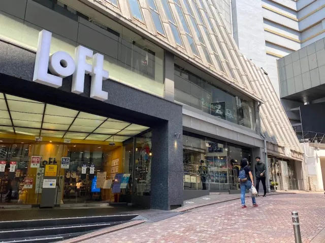 A shop entrance with a sign of raised white letters and an interior lit in yellow