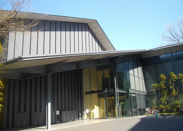A museum entrance with a low sloping roof and a vertical wooden wall
