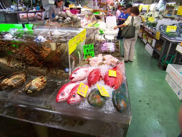 A fish stall with red fish and shellfish on ice