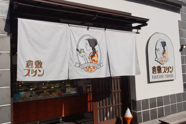 A white cloth curtain with a drawing of a woman in kimono, above a serving window and a display fridge